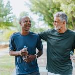 Two older men walking outside, laughing, living healthy